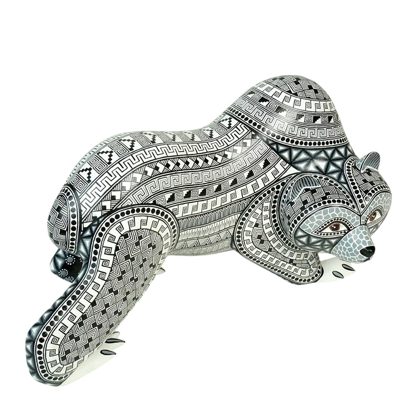 Mexican bear figurine handmade of wood and painted in black and gray over a snow white background.