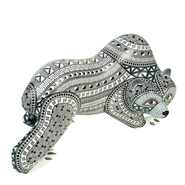 Mexican bear figurine handmade of wood and painted in black and gray over a snow white background.