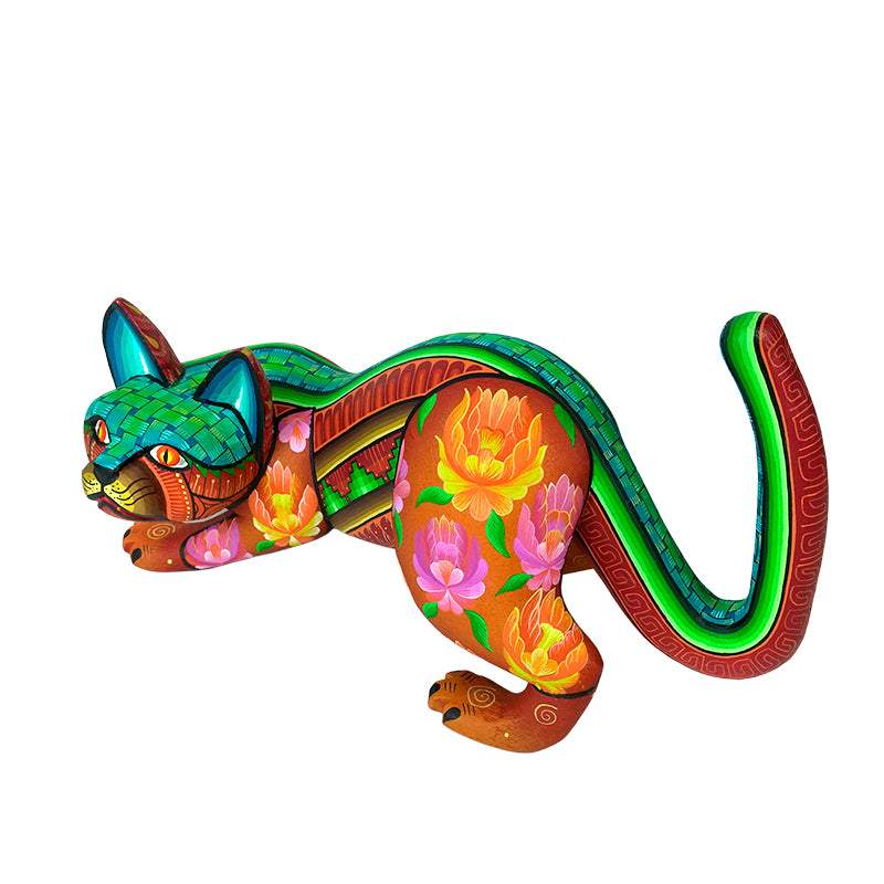 Colorful woodcarved cat-shaped figurine with floral patterns on a white background