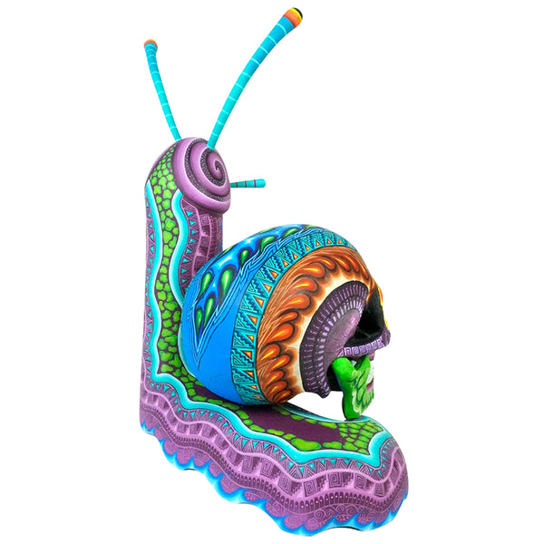 Unique Oaxacan woodcarving of a snail with a colorful Day of the Dead skull shell, painted in vivid purple, green, and turquoise tones.