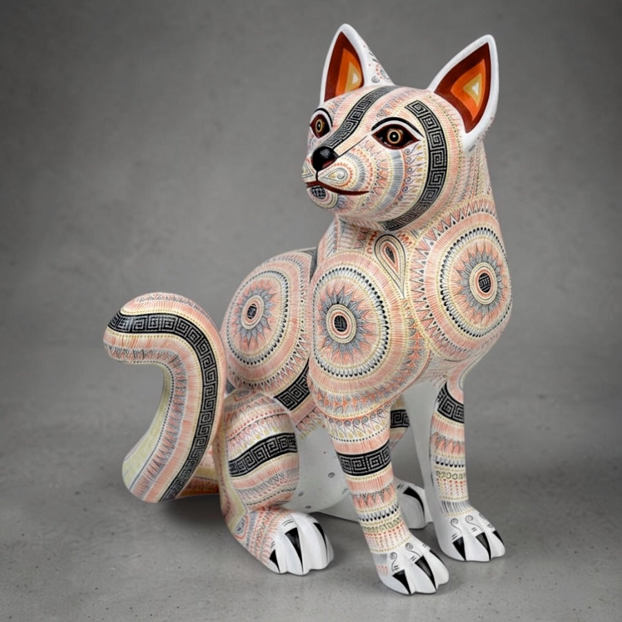Decorative handcrafted alebrije figurine with intricate patterns on a gray background