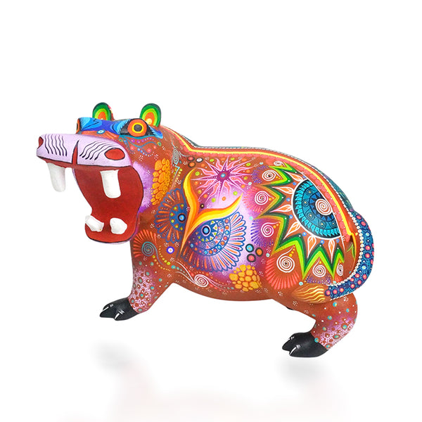 A brightly colored wooden hippo figurine with a vibrant sun and flower patterns on its body.