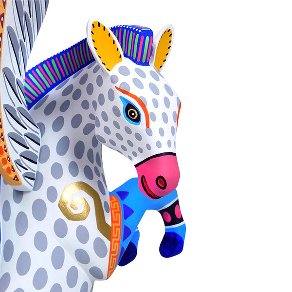 Expressive face of a woodcarved pegasus in white with blue, rose and golden accents