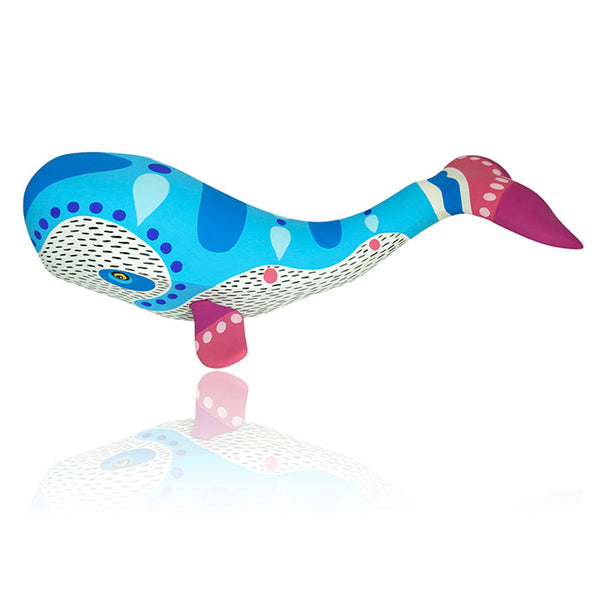 A colorful whale-shaped woodcarving with blue and pink patterns on a white background.