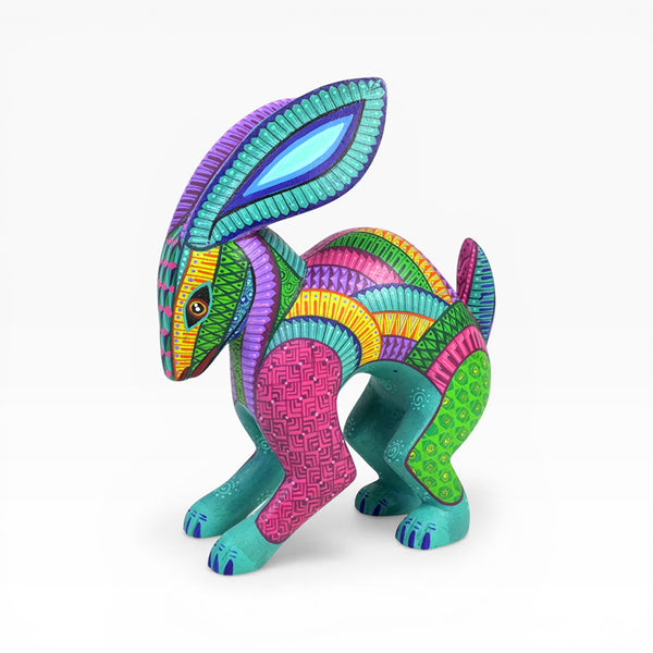 Colorful rabbit wood figurine, hand carved in Oaxaca with intricate patterns on a white background