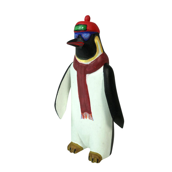 Penguin wood Alebrije figurine wearing a red hat and scarf on a white background