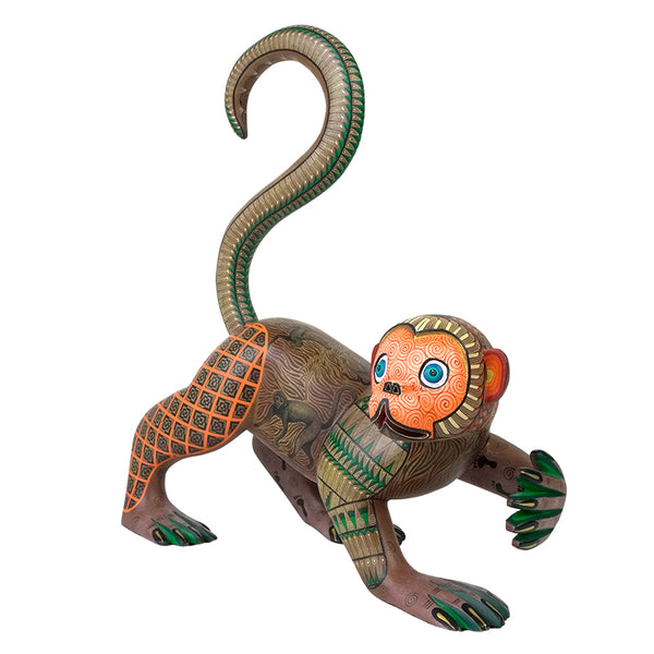 Mexican folk art  monkey wood figurine with intricate patterns on a white background