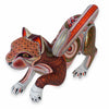 A handcrafted Mexican alebrije wooden cat figurine decorated with intricate geometric and floral patterns in brown, orange, white, and green, shown against a plain white background.
