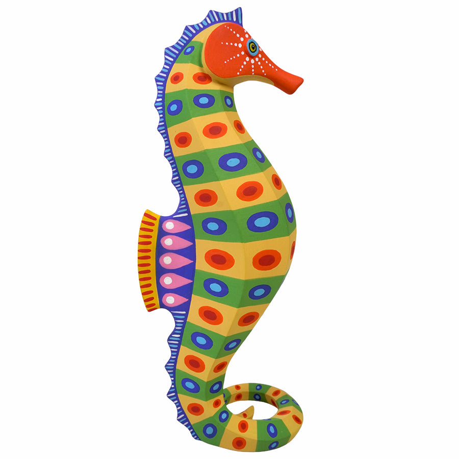 A colorful seahorse wood carving with a hand-painted folk art style, featuring green, yellow, blue, orange, and purple patterns, isolated on a white background.