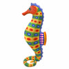 A colorful seahorse Alebrije woodcarving or decorative sculpture on a plain white background. The design features a yellow-green body with blue and orange oval patterns, a red-orange snout and head, and blue, purple, and orange details on the tail and fins.