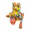 A colorful hand-painted Mexican folk art wooden frog figurine playing a small drum, isolated on a white background.